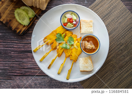 Chicken Satay served with peanut sauce and sweet sour sauce - Asian food Concept style on white plate 116884581