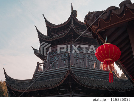 Traditional chinese architectural structure with red lantern in tranquil garden at dawn Traditional chinese architectural structure with red lantern in tranquil garden at dawn 116886055