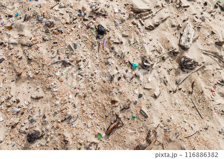 Microplastic rubbish on coastline. Plastic garbage in sand on ocean beach. 116886382