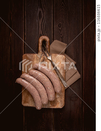 raw sausages in English with bacon, for grilling, on a cutting board, top view, no people, raw sausages in English with bacon, for grilling, on a cutting board, top view, no people, 116886615
