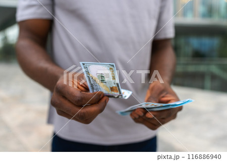 Man hands holding money dollar bills on urban street outdoor. Businessman hands counting currency money outdoors near office bank building. Unrecognizable man holding cash. Finance economy banking 116886940