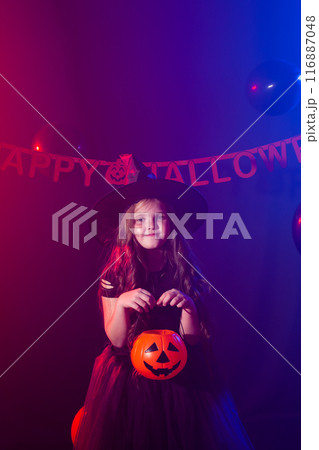 Happy laughing child girl in witch costume to Halloween holds jack lantern 116887048