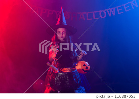 Cute child near cauldron with witches brew wearing witch costume in Halloween holiday. Scary and trick-o-treat Cute child near cauldron with witches brew wearing witch costume in Halloween holiday. Scary and trick-o-treat 116887053