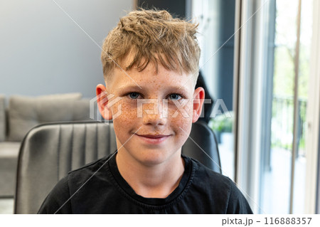A picture of a very happy child after being cut in a barbshop salon, he has a very nice cut and has freckles on his face. A picture of a very happy child after being cut in a barbshop salon, he has a very nice cut and has freckles on his face. 116888357
