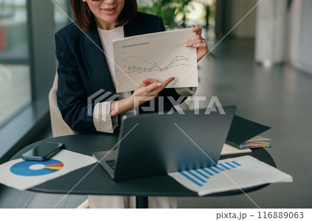 A businesswoman analyzes data and presents growth charts, showing leadership and professionalism 116889063