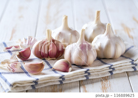 garlic on a white wooden table, selective focus. garlic on a white wooden table, selective focus. 116889625