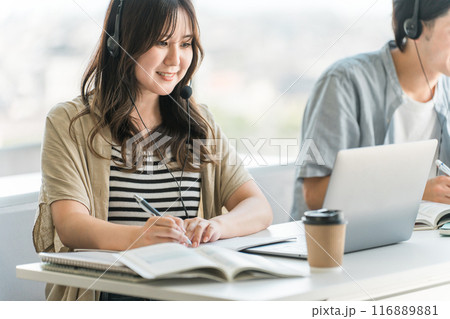 ヘッドセットをつけて通信教育・英会話教室・Web会議・オンライン授業・勉強をする大学生・高校生 ヘッドセットをつけて通信教育・英会話教室・Web会議・オンライン授業・勉強をする大学生・高校生 116889881