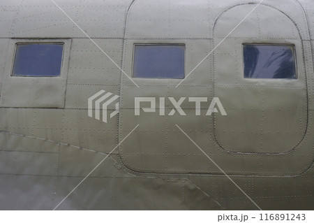 The fuselage of an old military airplane with doors and an illuminator. The fuselage of an old military airplane with doors and an illuminator. 116891243