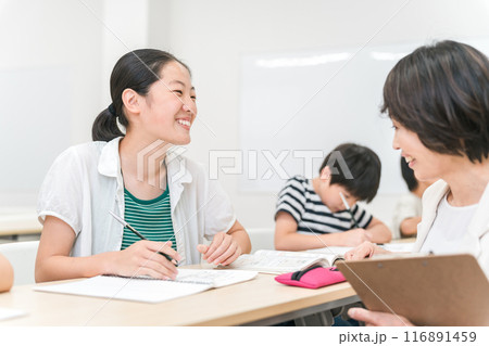 塾・学童で勉強する小学生の女の子と勉強を教えるアジア人女性講師・先生・学童指導員 塾・学童で勉強する小学生の女の子と勉強を教えるアジア人女性講師・先生・学童指導員 116891459