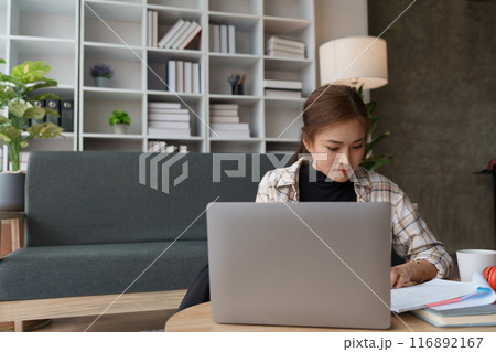 woman meticulously plans a finance audit, using a computer and calculator to review budget documents and ensure accuracy woman meticulously plans a finance audit, using a computer and calculator to review budget documents and ensure accuracy 116892167