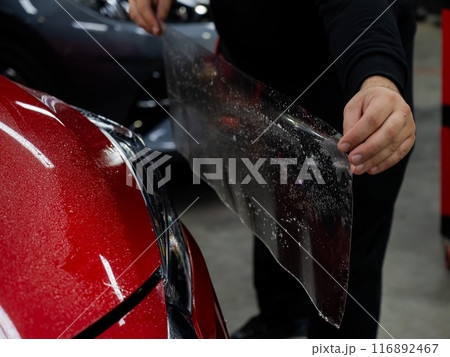 The process of applying protective vinyl film to car headlights in detailing. The process of applying protective vinyl film to car headlights in detailing. 116892467