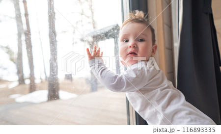 Baby boy standing by the patio window. Baby boy standing by the patio window. 116893335