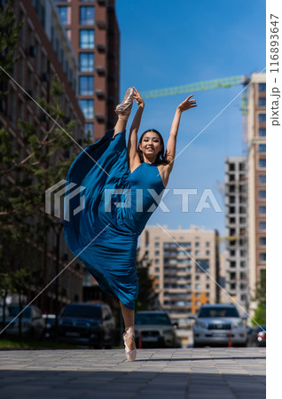 Beautiful Asian ballerina dancing outdoors. Urban landscape. 116893647