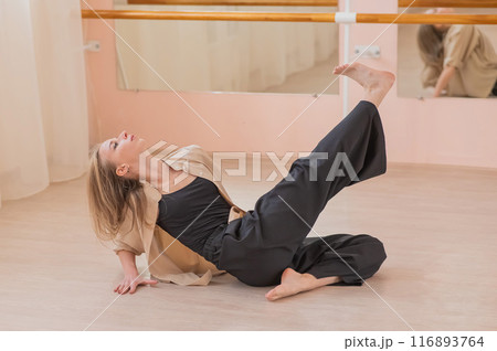 Caucasian woman dancing contemporary on the floor in a ballet class.  Caucasian woman dancing contemporary on the floor in a ballet class.  116893764