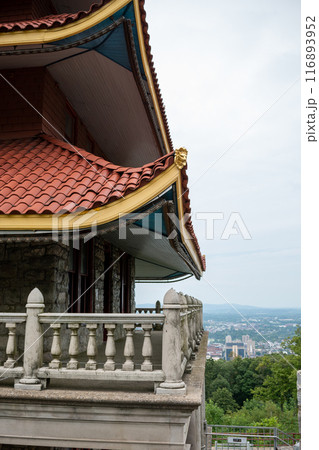 Overview of an Asian Pagoda looking over a forest and city. 116893952