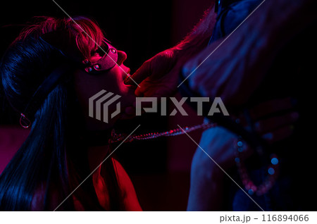 Role-playing games. Man putting finger in woman's mouth in cat mask. Role-playing games. Man putting finger in woman's mouth in cat mask. 116894066