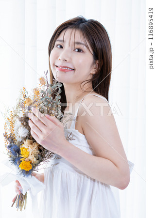 ドライフラワーの花束を持つ若い女性 116895419