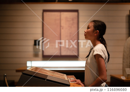 展示物を真剣に見る女の子 116896080