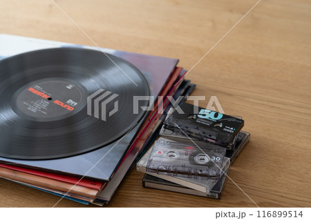 積み上げたレコードジャケットとLPレコードとカセットテープ 116899514