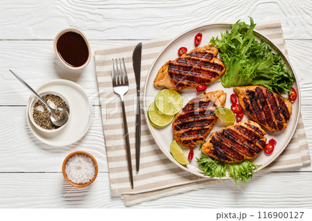 grilled chicken breasts wrapped in bacon on plate 116900127