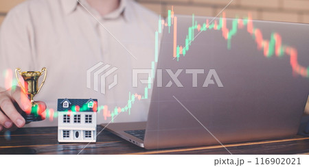 Businessman uses laptop to invest in real estate with growth stability chart. Double exposure 116902021