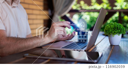 Businessman uses laptop to invest in real estate with growth stability chart. Double exposure Businessman uses laptop to invest in real estate with growth stability chart. Double exposure 116902039