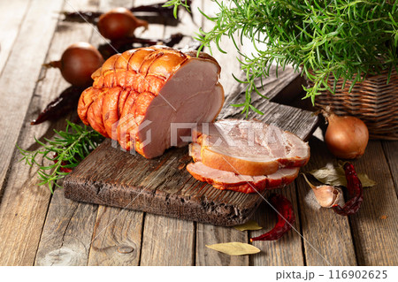 Smoked pork ham on a wooden table. 116902625