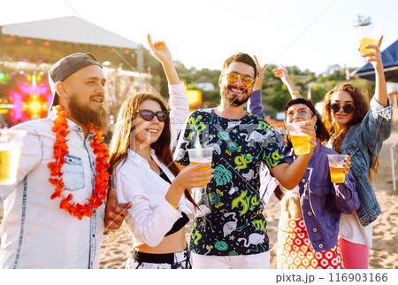 Young happy friends drinking beer and having fun at music festival together. Friendship. Young happy friends drinking beer and having fun at music festival together. Friendship. 116903166