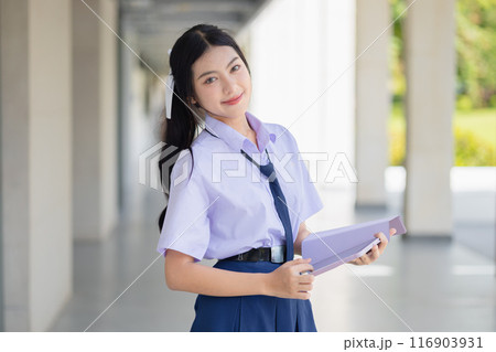 portrait school uniform teen girl standing happy smile indoor school campus for learning education back to school concept. portrait school uniform teen girl standing happy smile indoor school campus for learning education back to school concept. 116903931
