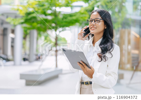 Business Marketing people phone call. Asian Indian working women smart girl with tablet smartphone contact at green park outdoor. 116904372