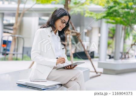 Business Young people. Asian Indian working women smart girl with tablet green park outdoor. Business Young people. Asian Indian working women smart girl with tablet green park outdoor. 116904373