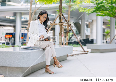 Business Young people. Asian Indian working women smart girl with tablet green park outdoor. 116904376