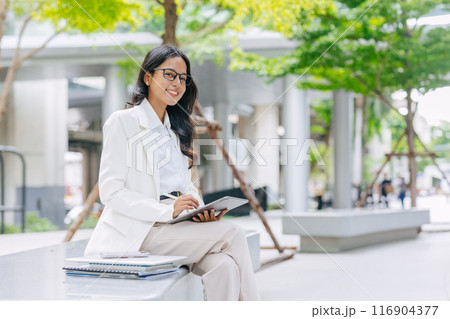Business Young people. Asian Indian working women smart girl with tablet green park outdoor. Business Young people. Asian Indian working women smart girl with tablet green park outdoor. 116904377