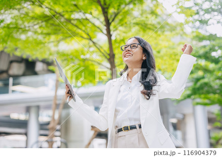 Success achievement people. Indian Business people happy hand rising working outdoor green city background. 116904379