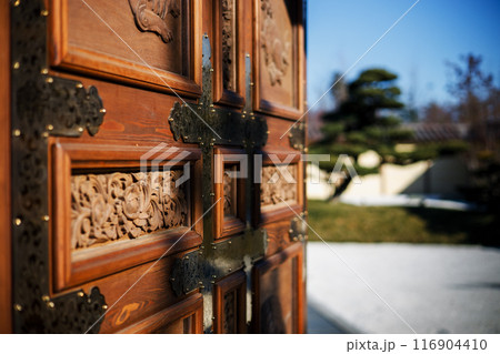 Wooden carved gate at the entrance to the Japanese garden 116904410