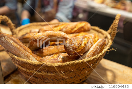 Bread, buns and bakery products are sold in a bakery. Homemade fresh bread in a wicker basket. Delightful assortment of freshly baked pastries. Food banner 116904486