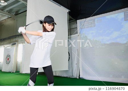 室内ゴルフ練習場で練習をする女性 116904870