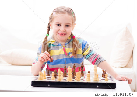 Cute little girl playing chess at home Cute little girl playing chess at home 116911307