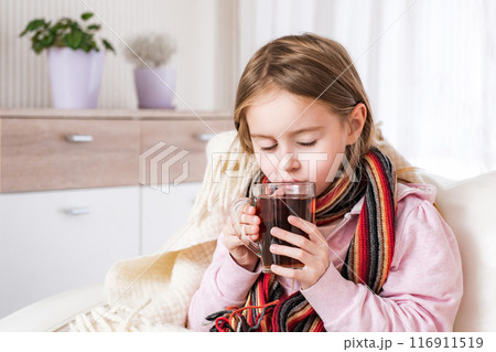 Little ill girl in scarf drinking tea 116911519