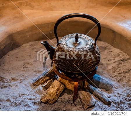 日本家屋の囲炉裏の上に置いてある鉄瓶 116911704