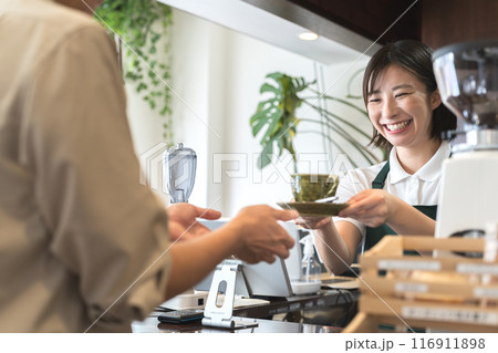 カウンターでコーヒーを手渡しする店員 116911898