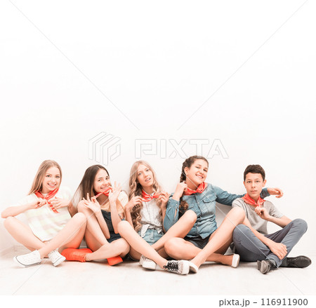 cute smiling tenagers sitting on the floor with legs crossed cute smiling tenagers sitting on the floor with legs crossed 116911900
