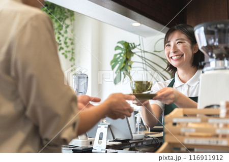カウンターでコーヒーを手渡しする店員 116911912