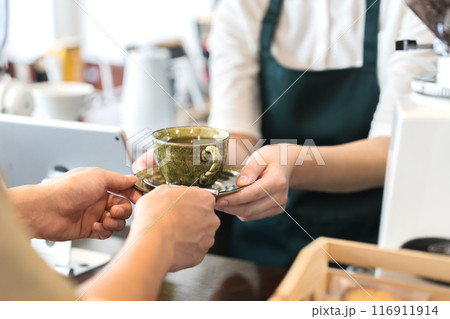 カウンターでコーヒーを手渡しする店員 116911914