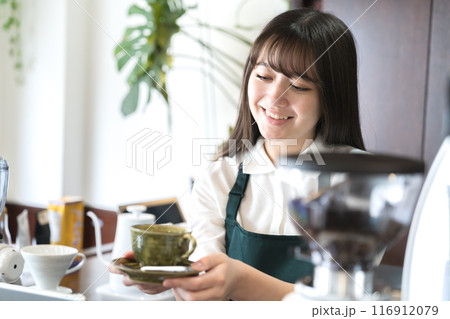 カウンターでコーヒーを手渡しする店員 116912079
