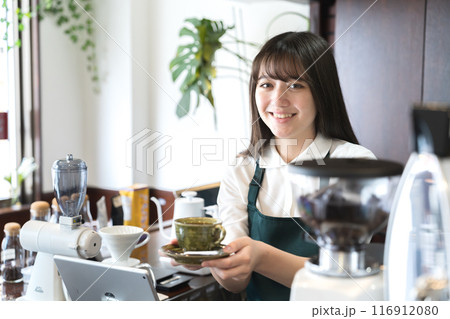 カウンターでコーヒーを手渡しする店員 116912080