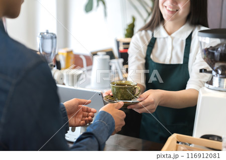 カウンターでコーヒーを手渡しする店員 116912081
