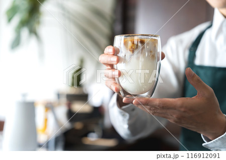 カフェオレを提供する男性の手元 116912091