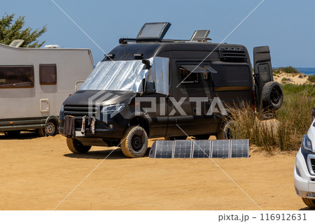 Black Camper Van with Solar Panels in Desert Black Camper Van with Solar Panels in Desert 116912631