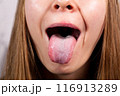 Female tongue. Close-up Of A Woman's Face Showing Her Clean Tongue 116913289